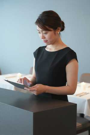 高級レストランで予約を確認する女性