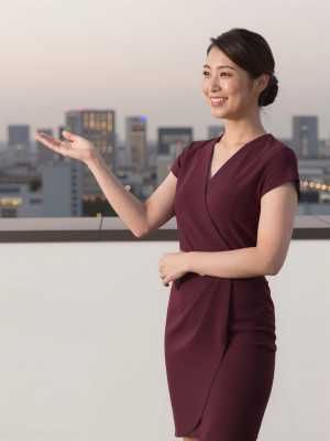 屋上バーで夜景を案内する女性