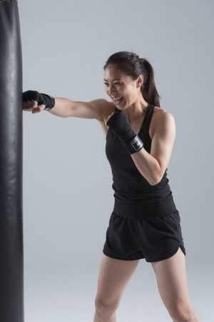 ボクシングジムでパンチを打つ女性