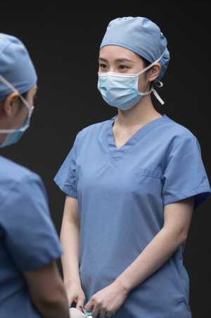 手術室で器具を渡す外科医