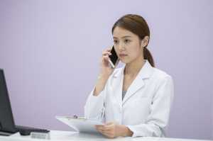 薬局で電話応対する薬剤師