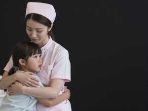 小児病棟で子供を抱きしめる看護師