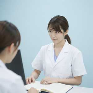 診察室で同僚と協議する医師