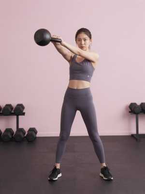 力強くケトルベルスイングをする女性