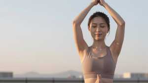 朝日で輝く木のポーズの女性