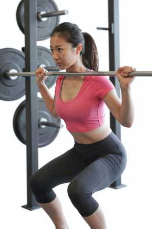 力強くデッドリフトを行う女性