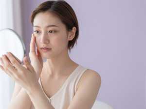 鏡で肌の調子を確認する女性