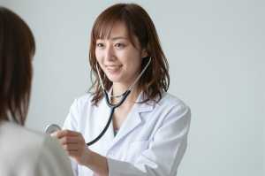 患者の心音を聞く女医