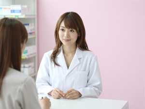 患者に薬を案内する薬剤師