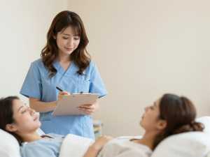 患者のバイタルを記録する看護師