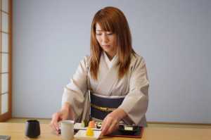 旅館で懐石料理を提供する女性