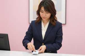 ホテル受付で鍵を整理する女性