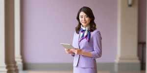 ホテルのエントランスで客を迎える女性