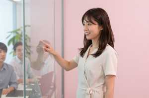 ガラス越しに説明する女性