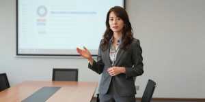会議でプレゼンするビジネスウーマン