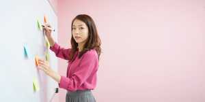 ホワイトボードで指導する女性