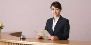 笑顔で案内するホテルコンシェルジュ