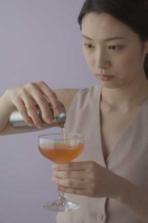 層状カクテルを注ぐバーテンダー