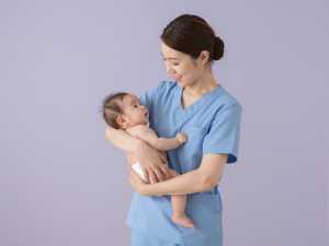 赤ちゃんを抱く優しい看護師