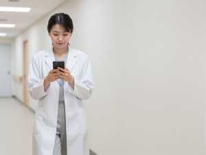 スマートフォンを見る女性医師