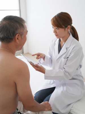 タブレットで説明する医師と高齢患者