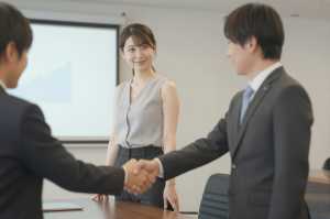 会議室で握手するビジネスパーソン