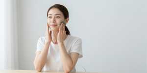 寝室でグアシャマッサージをする女性