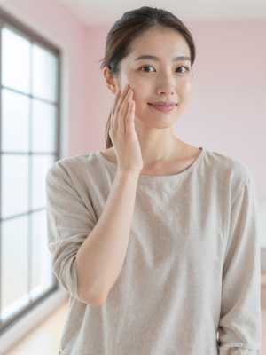 スキンケア後の肌に触れる女性