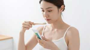 竹歯ブラシでオーラルケアをする女性