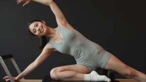 ピラティススティックでサイドベンドをする女性