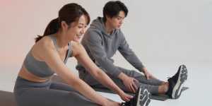 ジムのマットで脚をストレッチする男性