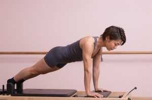 ピラティスリフォーマーで体幹を鍛える男性