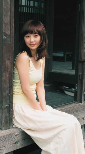 和風建築の木造デッキに座る若き女性の優雅なポートレート