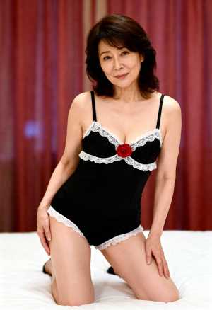 白いレースのトリムと前面に赤いバラが付いた黒いランジェリーセットを着て、ベッドの上で...。