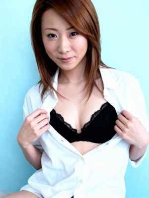 部分的に開いた白いシャツを着て、黒いレースのブラジャーが露出している、長い茶色の髪の...。