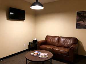 薄暗い待合室の中央には茶色の革張りのソファと丸い木のコーヒーテーブルが置かれている。