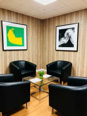 木製パネルと黒い革張りの椅子を備えたモダンなオフィス ロビー。