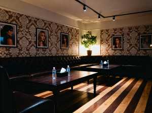 薄暗い部屋には、茶色の革張りのソファ、水筒とティッシュボックスを備えた 2 つの木製...。