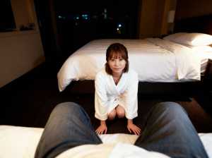 ホテルの一室で床にしゃがみ、無表情でカメラを見つめる白衣を着た女性を上空から写実的に...。