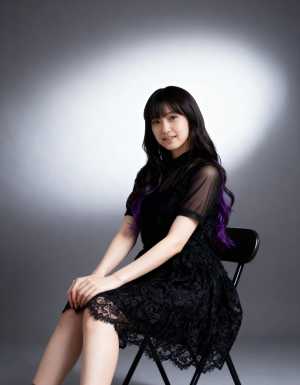 柔らかなグレーの背景とドラマチックな光源が背後にあるミニマルな環境で、椅子に座ってい...。