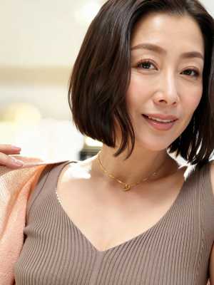 カメラに向かって微笑む、ショートボブのヘアカットの中年アジア人女性のポートレート。