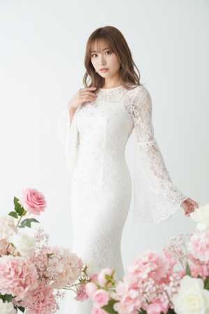 ピンクと白の花に囲まれた白いレースのウェディング ドレスを着た若い女性を正面カメラ ...。