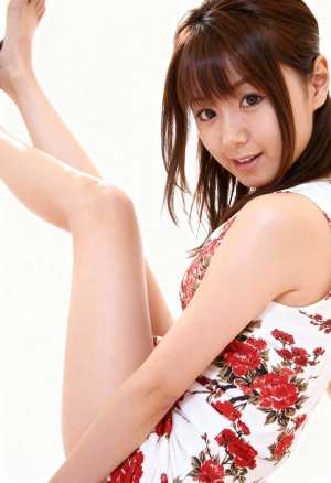 花柄のドレスを着て片足を空中に上げてポーズをとる若い女性を横から撮影した写実的な写真。