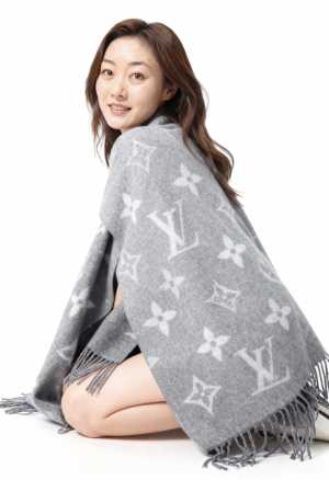 真っ白な背景のスタジオ設定で、フリンジが付いたグレーのルイ・ヴィトンのモノグラムショ...。