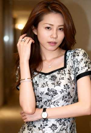 黒と白の花柄のシルバーのドレスを着て、思慮深い表情で自信を持ってポーズをとる若いアジ...。