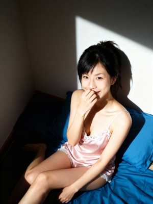 レースのトリムが付いたピンクのサテンのキャミソールを着て、居心地の良い寝室のベッドに...。