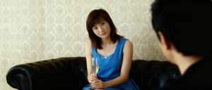 シャンパングラスを手に黒い革張りのソファに座り、注意深く座っている男性を見つめている...。