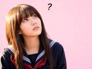 茶色のストレートの長い髪と前髪を持ち、紺色のセーラー服を着て、首に赤いスカーフを巻い...。