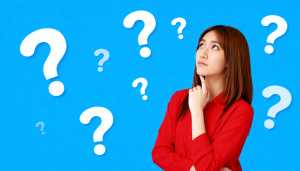 赤いシャツを着た長い茶色の髪の若い女性が、あごを手に乗せて画像の中央に立ち、思慮深い...。