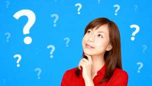 赤いシャツを着た長い茶色の髪の若いアジア人女性が、画像の中央に顎を手に乗せて座り、思...。